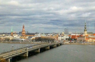 Bridge over river against cloudy sky