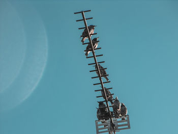 Low angle view of communications tower against clear blue sky