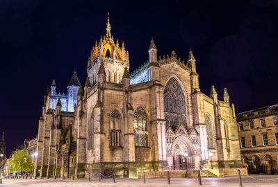 Low angle view of illuminated building against sky at night