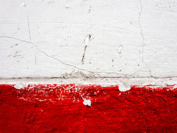 Close-up of red umbrella on white wall