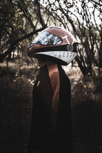 Rear view of woman standing against trees in forest