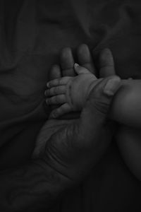 Father holding baby sons hand