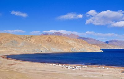 Scenic view of lake manasarovar and mountains against sky