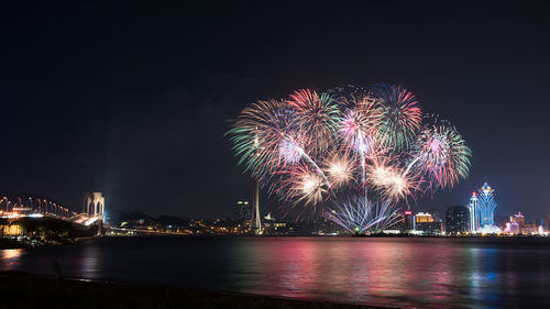 Illuminated city at night with firework display