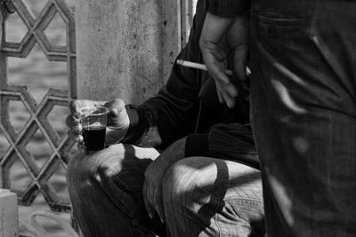 Men holding cigarette and drink outdoors