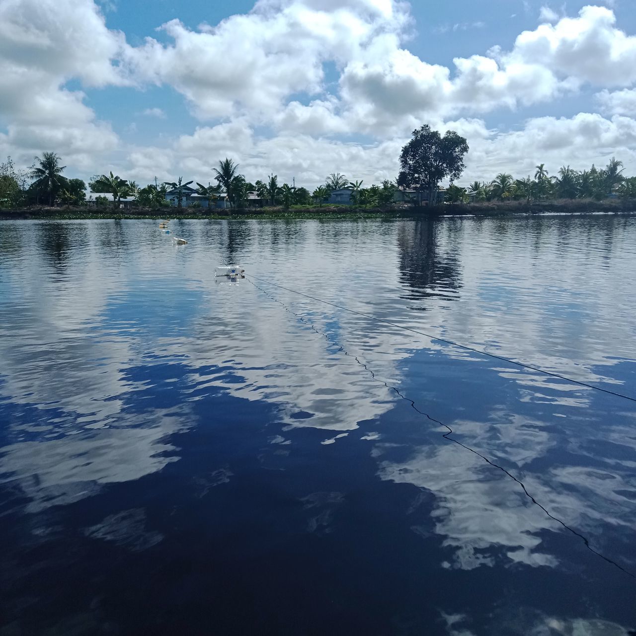 water, reflection, cloud, sky, tree, nature, tranquility, lake, beauty in nature, plant, scenics - nature, tranquil scene, no people, day, environment, blue, outdoors, shore, body of water, landscape, travel destinations, rippled, reservoir, idyllic, travel, land, non-urban scene, horizon