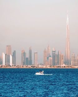 Sea by buildings against sky in city