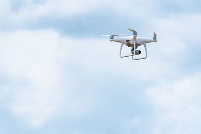 Low angle view of drone flying against sky