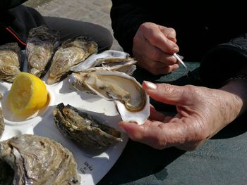 Cropped image of person holding fish in plate