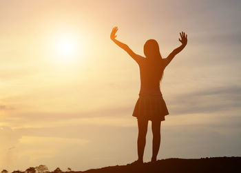 Low angle view of silhouette woman standing against sky during sunset