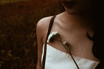 Midsection of woman with flower