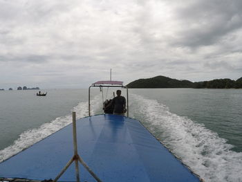 People on sea against sky