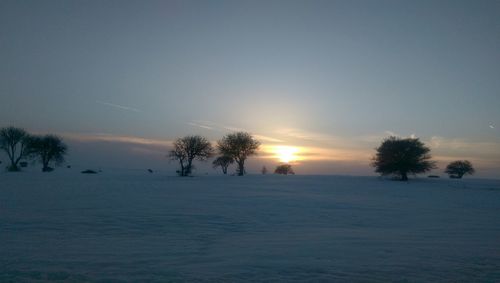 Scenic view of snow covered land during sunset