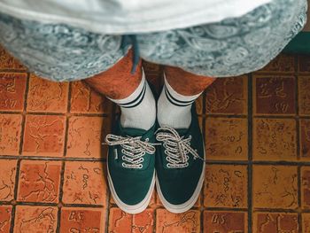 Low section of man standing on tiled floor