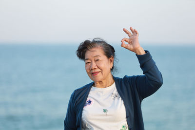 Portrait of smiling man standing against sea