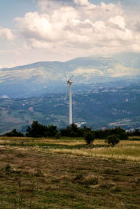 Windmill on field against sky