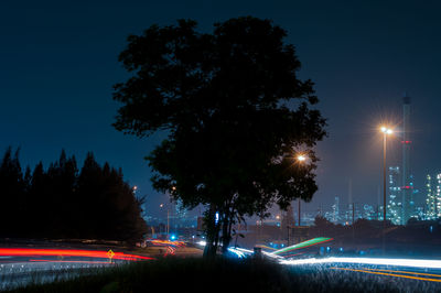 Light trails on road against sky at night