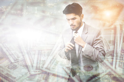 Digital composite image of businessman surrounded with paper currencies