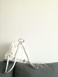 Close-up of bag on sofa against wall at home