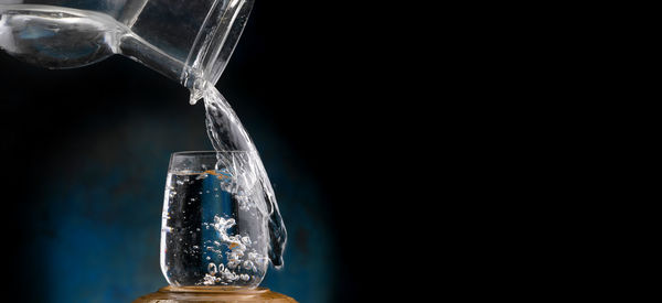 Close-up of glass bottle against black background