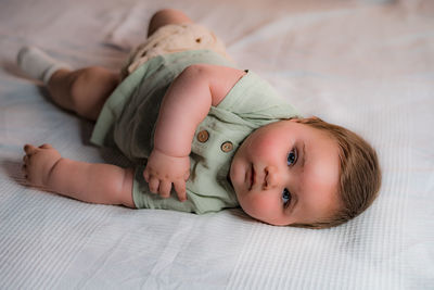 Portrait of cute baby lying on bed at home