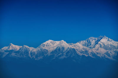 Scenic view of snowcapped mountains against clear blue sky