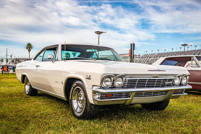 Vintage car parked on field against sky