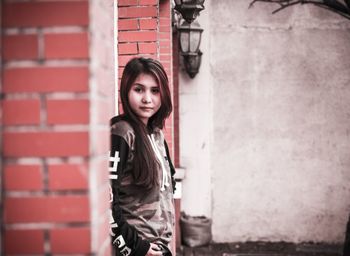 Side view portrait of woman standing amidst brick columns