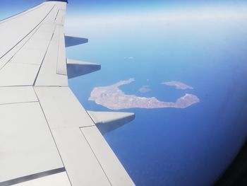 Airplane flying over sea against sky