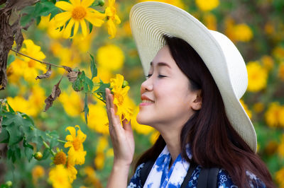 Women enjoy watching and smelling the clear flowers in the yellow flower garden, mexican sunflower.