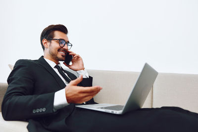 Young man using laptop while sitting on table