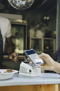 Cropped image of man doing contactless payment at counter