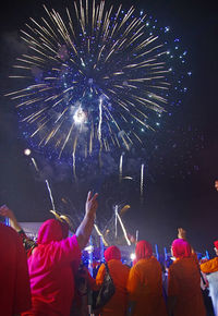 People enjoying firework display at night