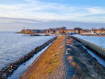 Scenic view of sea by city against sky