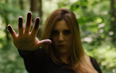 Woman showing stop gesture in forest