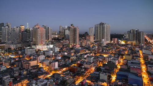 Aerial view of illuminated buildings in city against sky