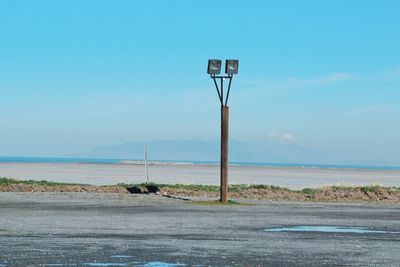 Road by sea against clear blue sky