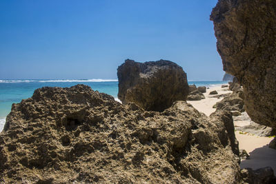 Rock formation on beach against sky