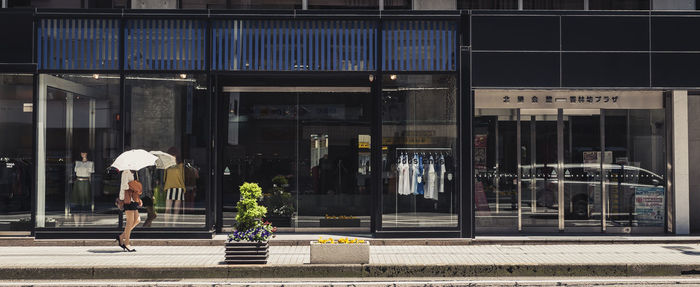 Woman walking on footpath in city