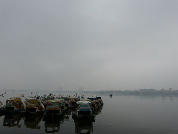 Boats in sea against clear sky