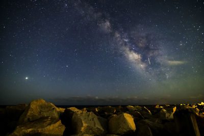 Scenic view of rocks against star field at night