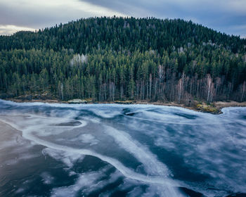 Scenic view of waterfall in forest against sky