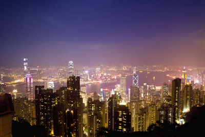 Illuminated cityscape against sky at night