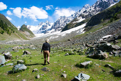Rear view of man walking on field