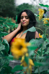 Portrait of beautiful woman standing amidst plants