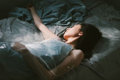 High angle view of young woman sleeping in bed