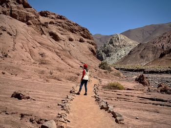 Rear view of woman walking on mountain