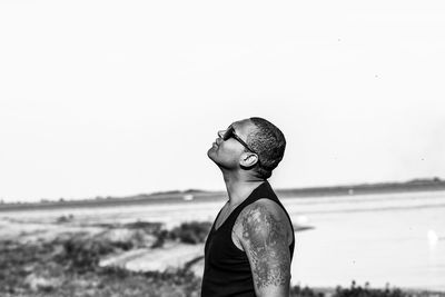 Man looking up while standing at beach