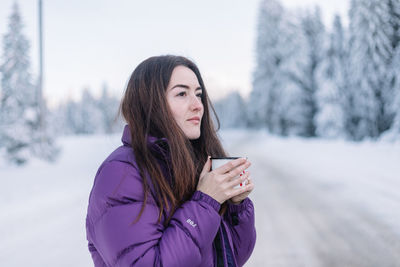 Young woman using mobile phone during winter