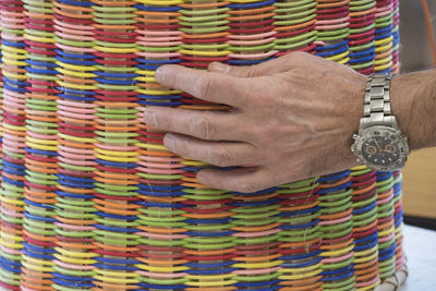 Close-up of human hand holding multi colored pencils